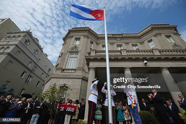 Cuban Foreign Minister Bruno Rodriguez applauds as the Cuban flag is raised in front of the country's embassy for the first time in 54 years July 20,...