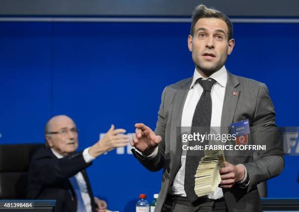 British comedian Simon Brodkin holds fake dollars note next to FIFA president Sepp Blatter gestures during a protest at a press conference at the...