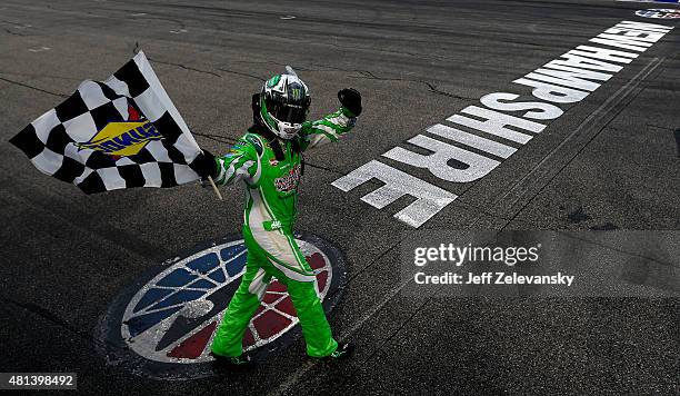 Kyle Busch, driver of the Interstate Batteries Toyota, celebrates with the checkered flag after winning the NASCAR Sprint Cup Series 5-Hour ENERGY...
