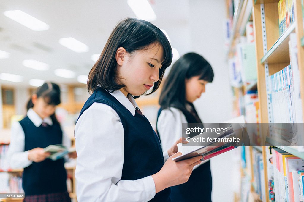 Japanische weibliche Studenten Lesen in der Bibliothek