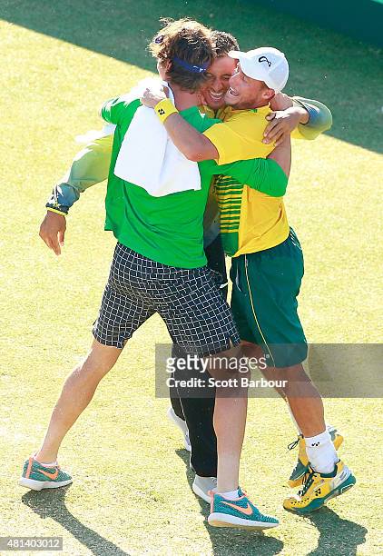 Thanasi Kokkinakis and Nick Kyrgios run on court to congratulate teammate Lleyton Hewitt of Australia as he celebrates winning the reverse singles...