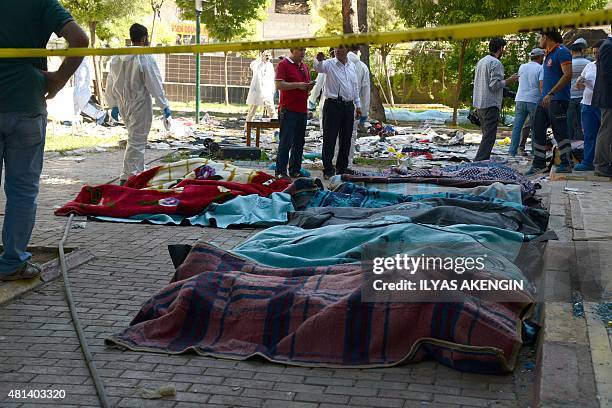 Turkish officials work on the site of an explosion in the town of Suruc, not far from the Syrian border, on July 20, 2015. At least 30 people were...