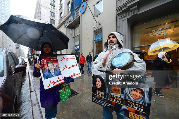 Group of Egyptians living in New York City, shouts slogans and holds placards outside the Empire State building on March 29, 2014 during a...