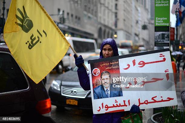 Group of Egyptians living in New York City, shouts slogans and holds placards outside the Empire State building on March 29, 2014 during a...