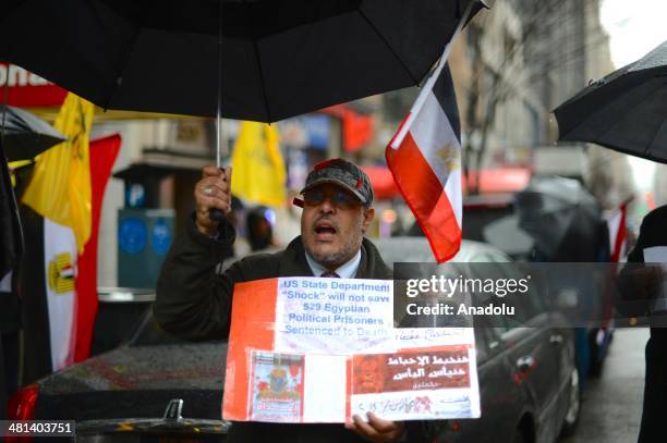 Group of Egyptians living in New York City, shouts slogans and holds placards outside the Empire State building on March 29, 2014 during a...