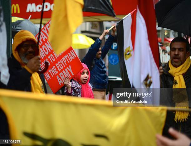 Group of Egyptians living in New York City, shouts slogans and holds placards outside the Empire State building on March 29, 2014 during a...