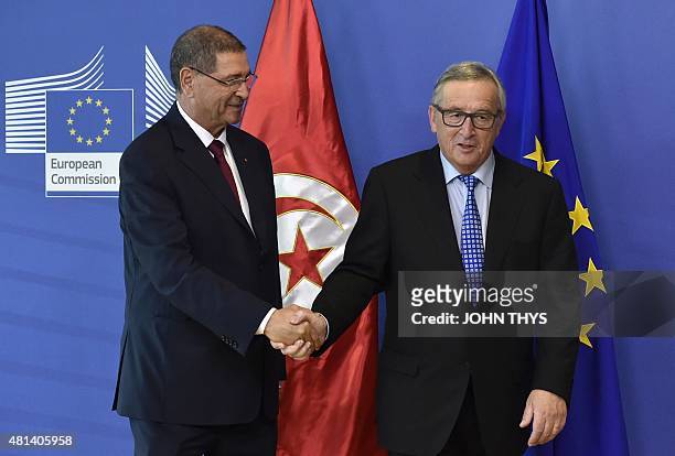 European Union Commission president Jean-Claude Juncker shakes hands with Tunisian Prime Minister Habib Essid before a meeting at the EU Headquarters...