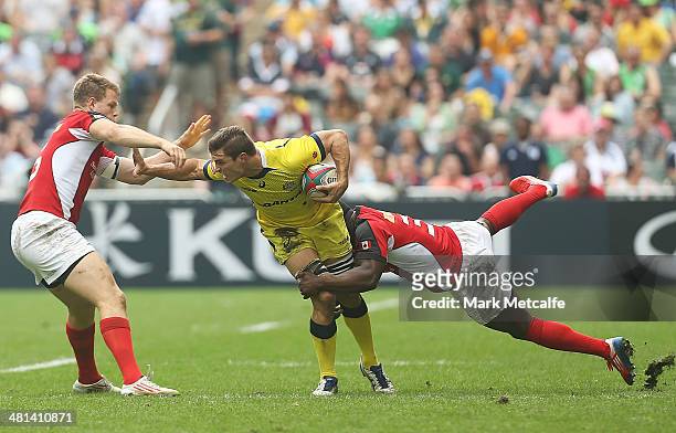Ed Jenkins of Australia is tackled during the Cup quarter-final match between Australia and Canada during day three of the 2014 Hong Kong Sevens at...