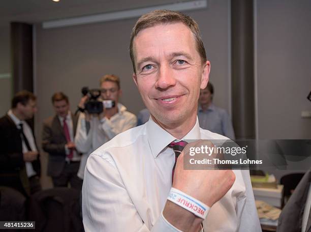 Bernd Lucke, former co-head of the Alternative fuer Deutschland political party, showes his access bracelet with the slogan 'Weckruf 2015' at the...