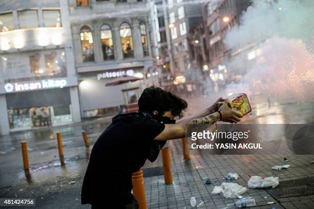 Protester fires fireworks at Turkish riot police during a demonstration on July 20, 2015 in Istiklal avenue in Istanbul, after a suicide bombing in...