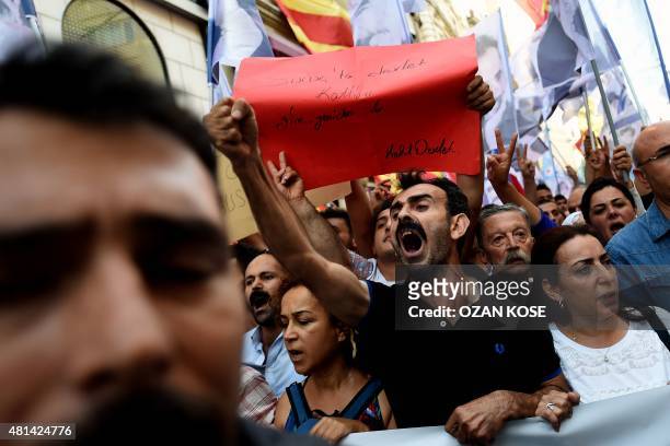 Protestors shout slogans and hold a placard reading 'Goverment massacre in Suruc- killer goverment' as they march on Istiklal Avenue in Istanbul...