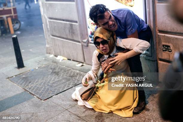 Couple react after being hit with tear gas during a demonstration on July 20, 2015 in Istiklal avenue in Istanbul, after a suicide bombing in the...