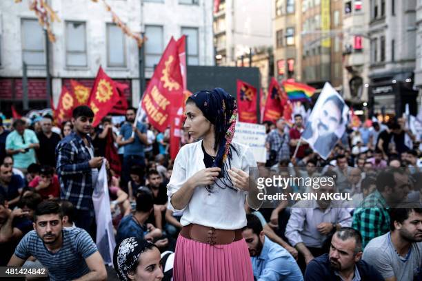 Woman stands among protesters during a demonstration on July 20, 2015 in Istiklal avenue in Istanbul, after a suicide bombing in the Turkish town of...