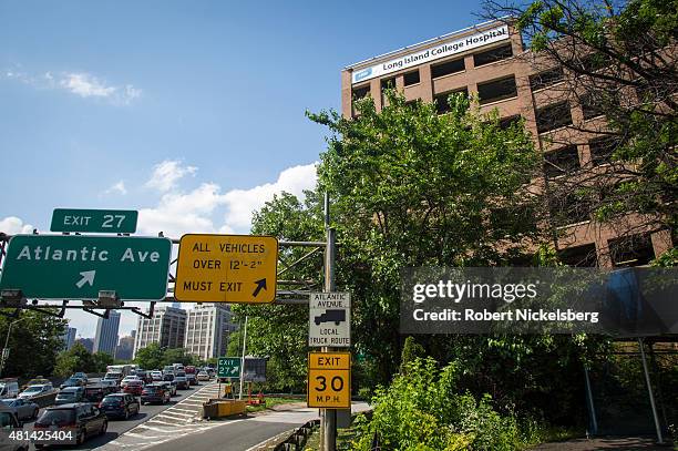 Traffic moves along the Brooklyn Queens Expressway adjacent to the Long Island College Hospital campus, right, June 19, 2015 in the Brooklyn borough...