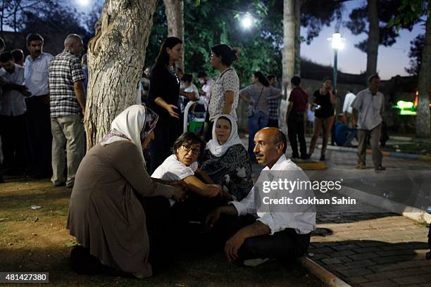 Relatives of the people who lost their loved ones wait near the site of a bomb attack on July 20, 2015 in Suruc, Turkey. At least 30 people were...
