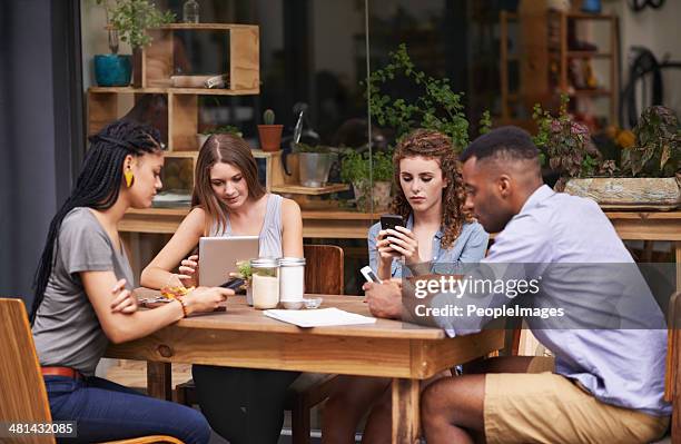 relaxing with the best of friends - african american restaurant texting stockfoto's en -beelden