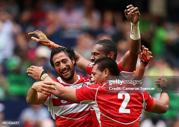 Jamie Henry, Lomano Lemeki and Lote Tuqiri of Japan celebrate winning the Qualifying semi-final match between Japan and Russia during the 2014 Hong...