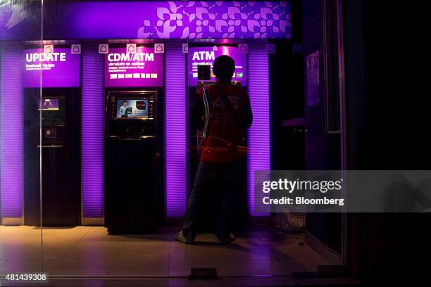 Customer uses an automated teller machine at a Siam Commercial Bank branch at night in the Sukhumvit area of Bangkok, Thailand, on Monday, July 20,...