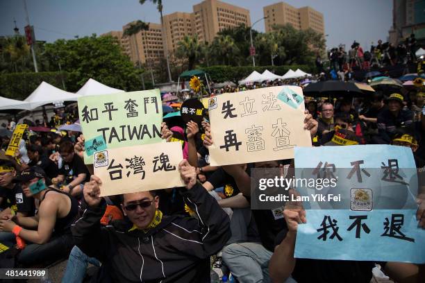 Protesters hold up signs during a rally called by the student groups occupying the Legislature Yuan on March 30, 2014 in Taipei, Taiwan. Taiwanese...