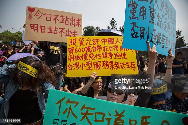 Protesters hold up signs during a rally called by the student groups occupying the Legislature Yuan on March 30, 2014 in Taipei, Taiwan. Taiwanese...