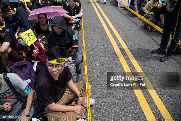 People squat on the ground as ten of thousand protesters attend the rally called by the student groups occupying the Legislature Yuan on March 30,...