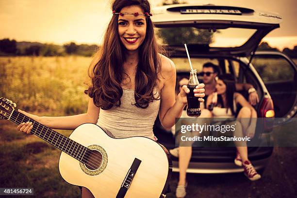 smiley country guitarist on a rural road - touring music festival stock pictures, royalty-free photos & images