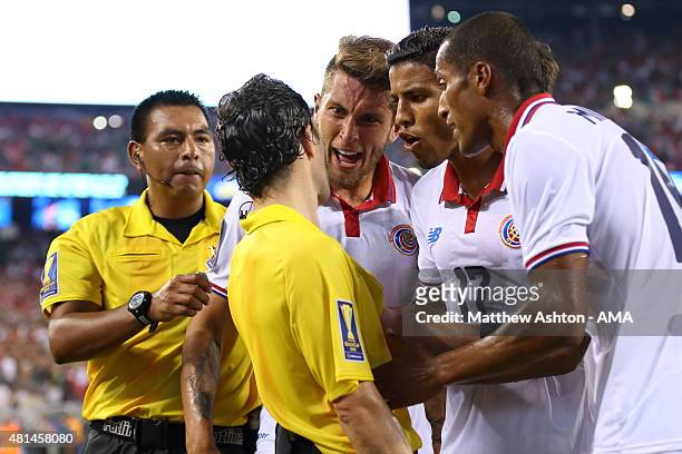 Francisco Calvo, Johan Venegas and Junior Diaz of Costa Rica appeal to the assistant referee about the last minute penalty awarded to Mexico during...