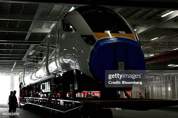 Members of staff observe a Class 800 Intercity Express train railcar, manufactured by Hitachi Ltd., as the vehicle sits loaded on the Hawaiian...