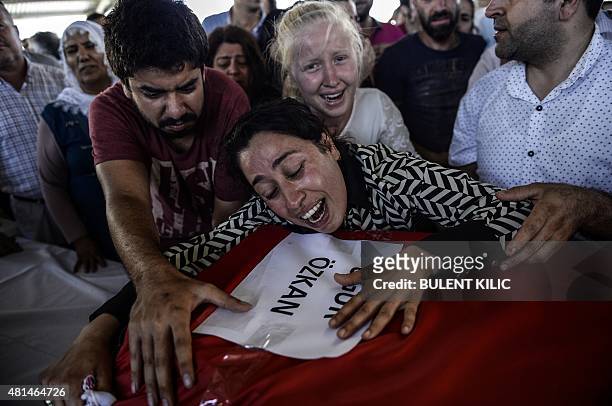 Mourners react over coffins in Gaziantep on July 21 during a funeral ceremony for victims following a suicide bomb attack the day before which killed...