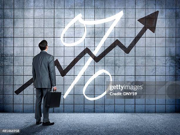 businessman looking at prospect of higher interest rates - percentage sign stock pictures, royalty-free photos & images