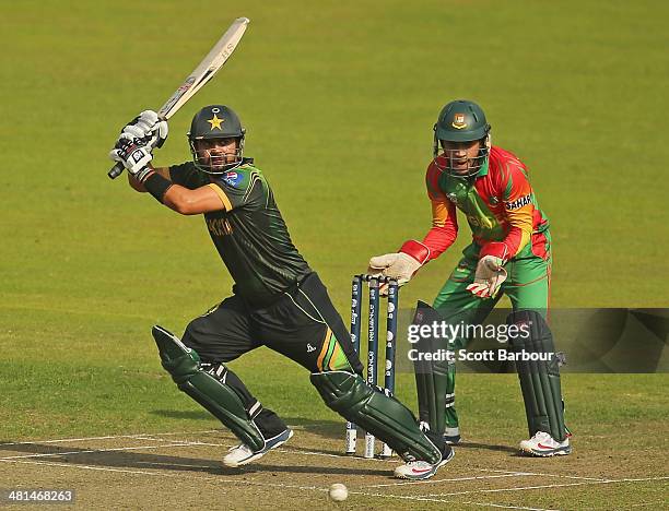 Ahmed Shehzad of Pakistan bats as Mushfiqur Rahim of Bangladesh looks on during the ICC World Twenty20 Bangladesh 2014 match between Pakistan and...