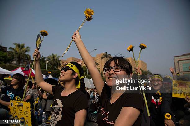 Protesters hold flowers and shout slogans as over two hundred thousand people rally on March 30, 2014 in Taipei, Taiwan. Taiwanese student protesters...