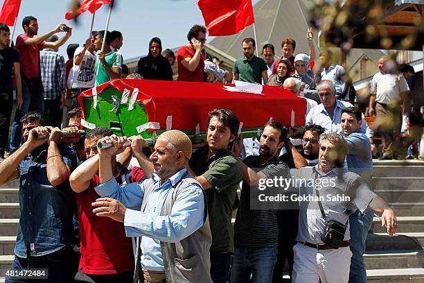 Mourners carry a coffin during a funeral ceremony for the victims of a suicide bomb attack yesterday which killed 32 people in the southern Turkish...