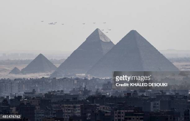 Three French made Rafale fighter jets fly with other Egyptian air force warplanes above the great pyramids in Giza, on the outskirts of Cairo, on...