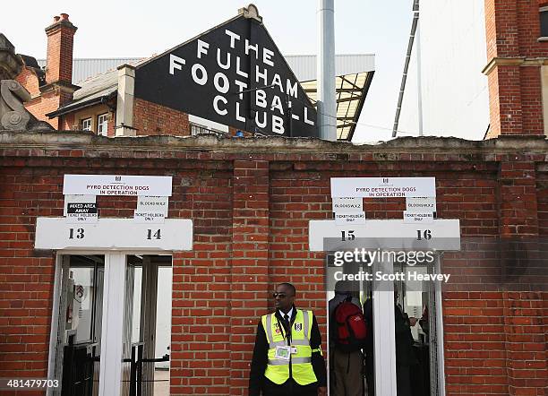 Steward patrols the turnstiles prior to the Barclays Premier League match between Fulham and Everton at Craven Cottage on March 30, 2014 in London,...