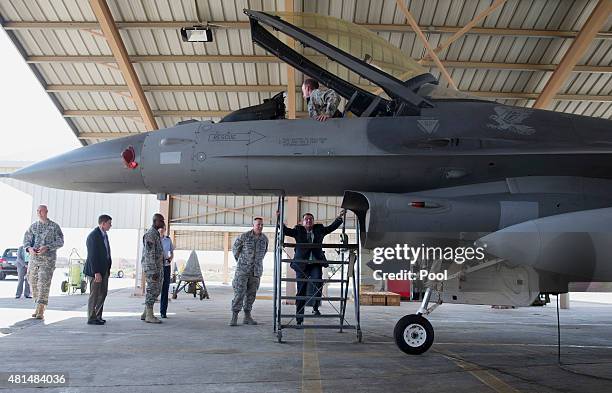 Defense Secretary Ash Carter climbs down after talking with Staff Sgt. Jesse Simmons, above in the cockpit of an F-16 Air Force fighter, as Chief...