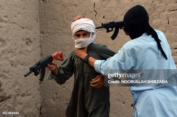 In this photograph taken on July 18 Afghan children play with plastic guns as they celebrate the second day of Eid al-Fitr which marks the end of the...