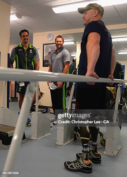 Australian cricket player's Mitchel Johnson and Ryan Harris talk to James Wilson as they visit Headley Court Military Rehabilitative Centre on July...
