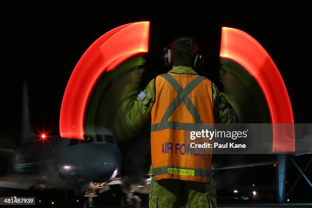 Signalman directs a RAAF P3 Orion for parking after returning from a search mission for debris from Malaysia Airlines flight MH370 at RAAF base...