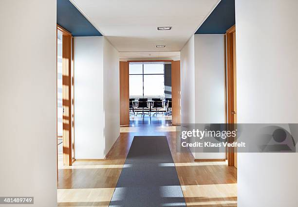 empty stylish conference room at end of corridor - office door open stockfoto's en -beelden