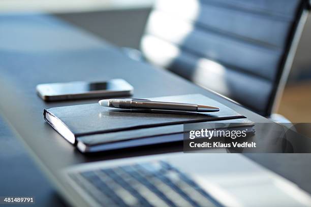 close-up of notebook with pen on top,phone in back - büromaterial stock-fotos und bilder