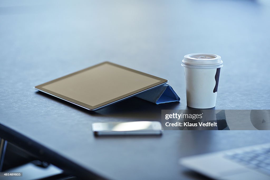 Still-life of tablet, to-go coffee & phone