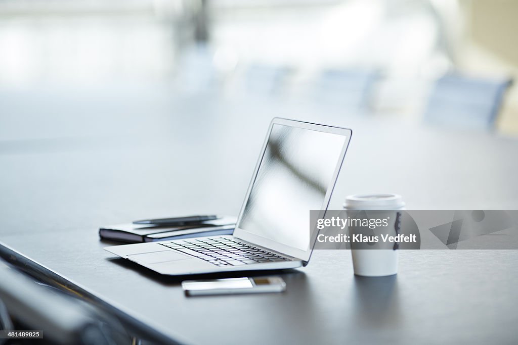 Still-life of laptop, phone & to-go coffee