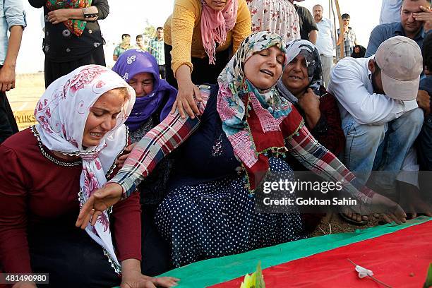 Relatives of a victim who was killed in Monday's bomb blast mourn during a funeral ceremony at a cemetery on July 21, 2015 in Suruc, Turkey. The bomb...