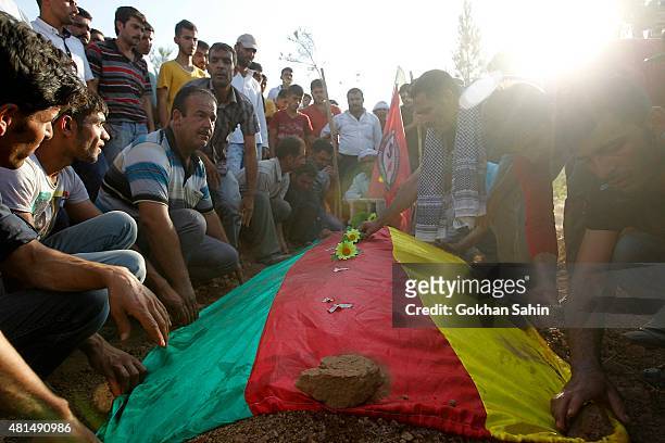 Relatives of a victim who was killed in Monday's bomb blast mourn during a funeral ceremony at a cemetery on July 21, 2015 in Suruc, Turkey. The bomb...