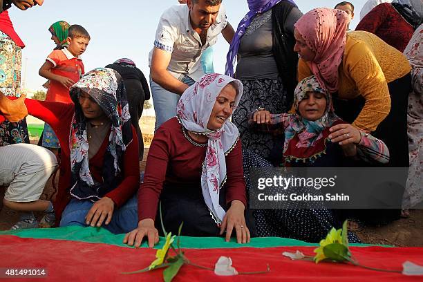 Relatives of a victim who was killed in Monday's bomb blast mourn during a funeral ceremony at a cemetery on July 21, 2015 in Suruc, Turkey. The bomb...