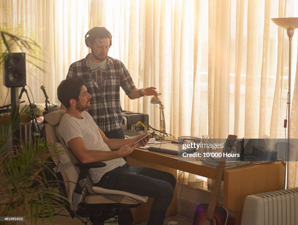 Man playing a man a song from an tablet computer