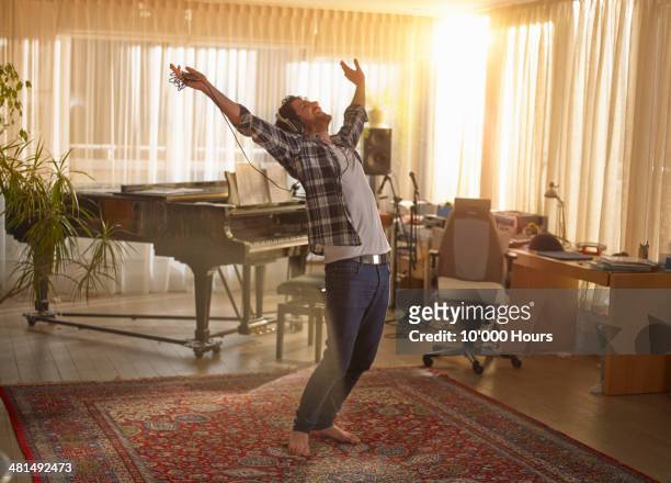 man dancing with headphones on - braccia alzate foto e immagini stock