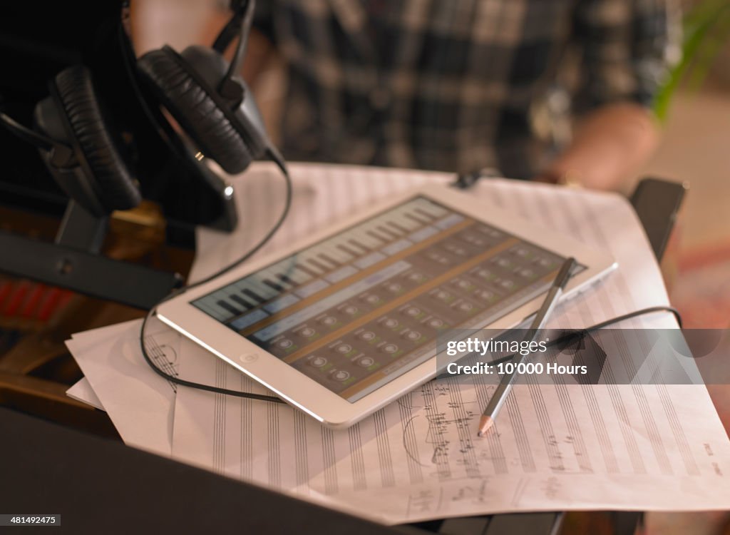 Computer tablet on top of a piano with music app