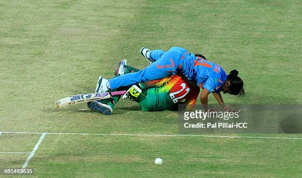 Poonam Yadav of India collides with Nuzhat Tasnia of Bangladesh as she tries to stop a ball of her own bowling during the ICC Women's World Twenty20...